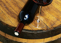 wine bottle and wine glass on top of wine barrel