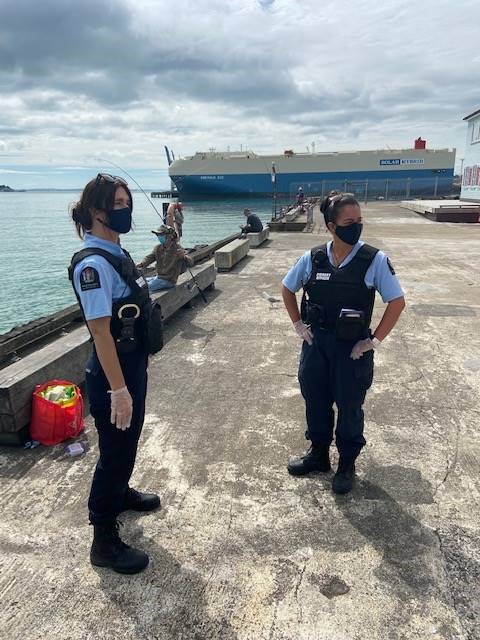 2 Auckland fishery officers at the wharf wearing face masks.