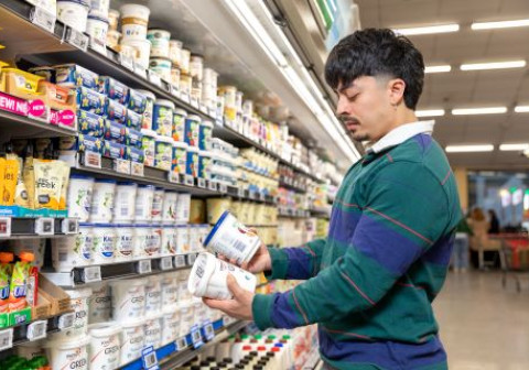 Young man reading labels in a supermarket