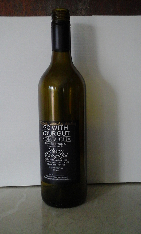 A glass bottle of kombucha, berry delightful flavour.