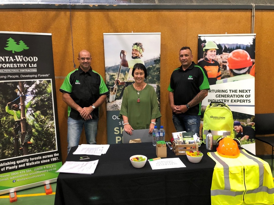 People standing behind a table with information on Intrawood Forestry Ltd