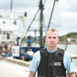 Kyall - Fisheries officer in uniform standing on a wharf
