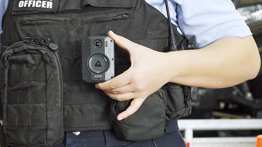 A close up image of a fisheries officer in uniform with a body worn camera.