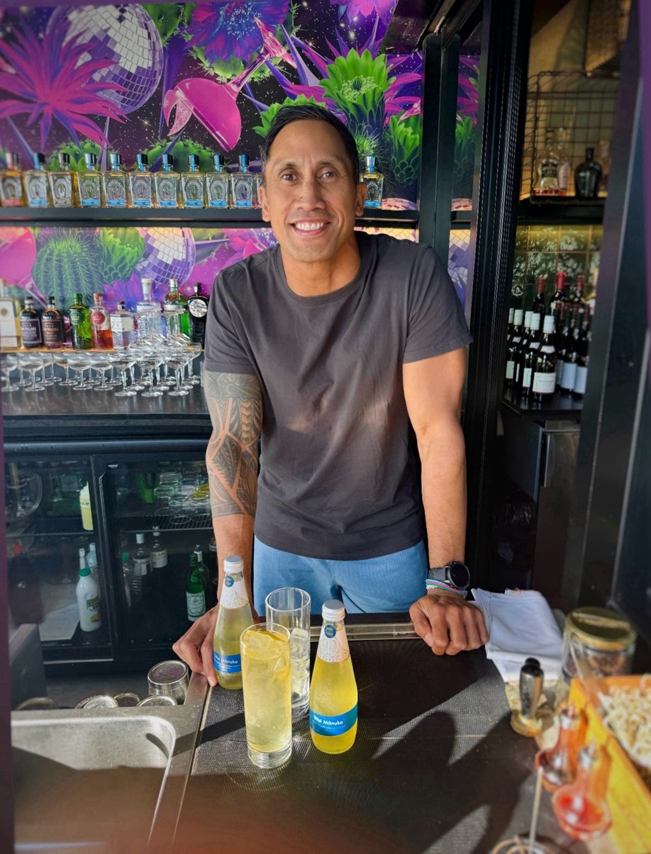 Joe Harawira standing at a bar with drinks