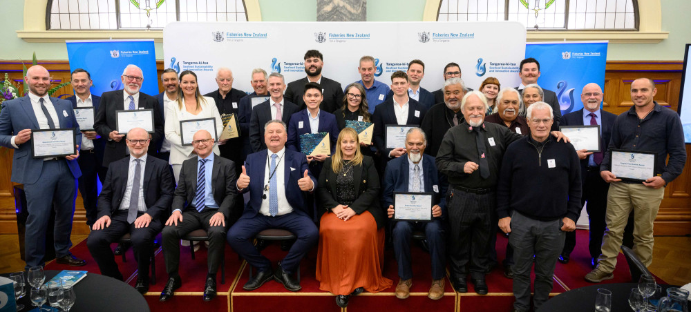 Group picture of people wearing suits and holding certificates.
