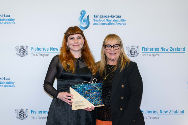 Two women holding an award.