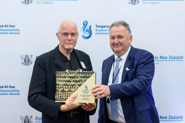 Two men holding an award.