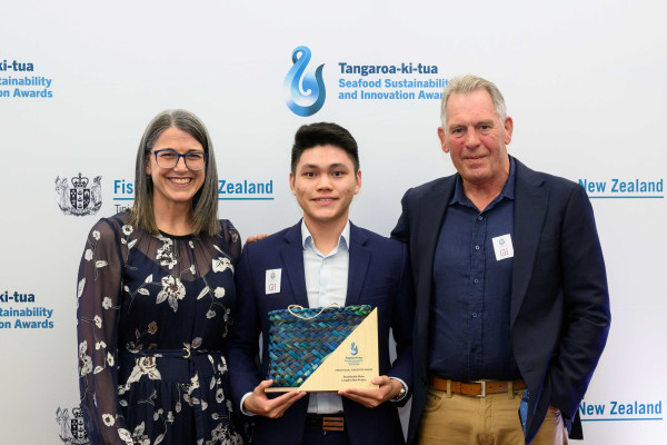 Three people holding an award.