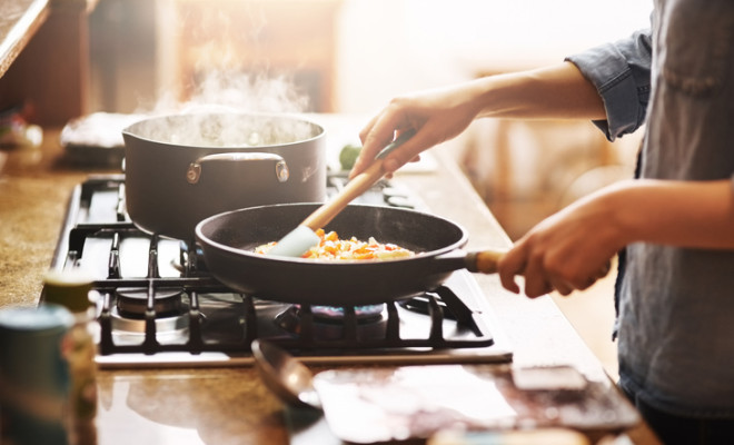 Cropped shot of a young woman preparing a meal at home