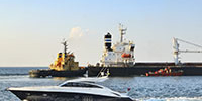 speedboat passing cargo ship