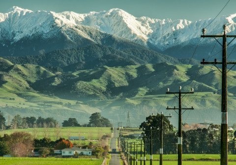 Long straight road with snowing mountain in horizon.