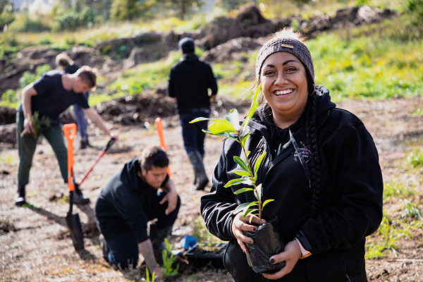 Photo of Freda walker planting trees with a bunch of people planting in the background