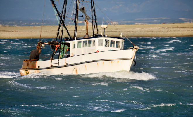 Small fishing trawler in rough seas.