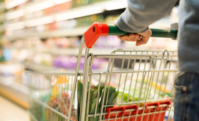 Full grocery cart in supermarket alley.